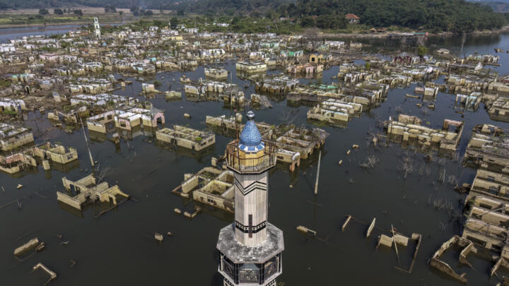 An aerial view taken on July 30, 2026 shows a mosque and surrounding buildings in Somang village in Lebak in Indonesia's western Banten province, which was deliberately flooded to make way for the construction and filling of the Karian Dam that opened in 2023 and has now re-emerged due to the El Nino-driven drought. Indonesia believes cloud seeding can help it tackle a wildfire season that experts say is on track to be among the worst in years, driven by a strong El Nino.