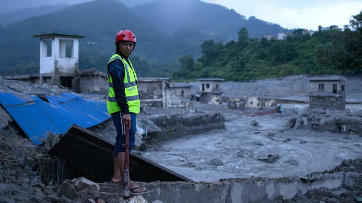 A rescue worker looks on at the site of damaged buildings in the aftermath of flash floods at Trishuli Bazar in Nepal's Nuwakot district on August 29, 2026