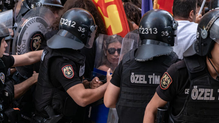 Turkish anti riot police officers push protesters as they surround them during a demonstration against the arrests of LGBTQ activists in Izmir, on September 14, 2026