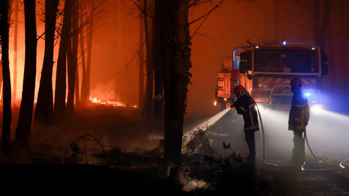 Firefighters work to put out flames burning in Luglon, France