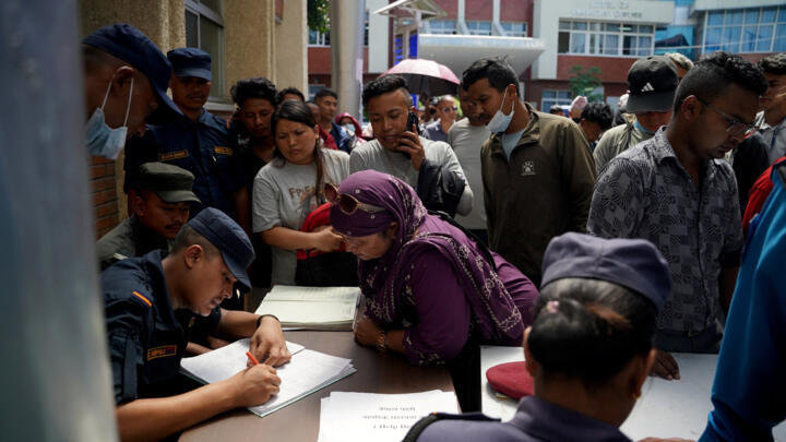 Family members gather in a hospital to check list of injured people following deadly floods, in Kathmandu, Nepal, August 27, 2026.
