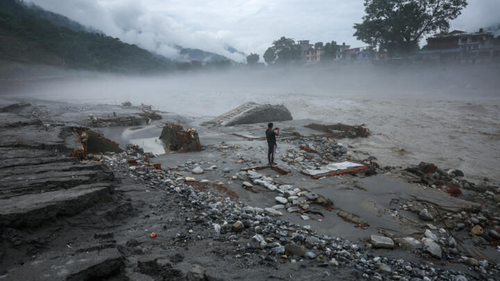 A man takes pictures on a devastated area near the Trishuli River, following the deadly flash floods and a mudslide, in Devighat, Nuwakot district, Nepal, September 4, 2026.