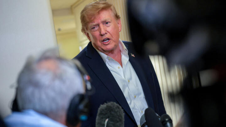 U.S. President Donald Trump speaks to members of the media aboard Air Force One, en route to Joint Base Andrews, Maryland.