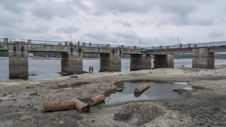 People walk on a central beach as a water in Dnipro river dropped for more than 4 meters after the explosion of the Kakhovka dam in Zaporizhzhia, Ukraine, July 9, 2023