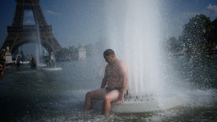 A person cools off at Trocadero fountain near the Eiffel Tower during a heat wave in Paris, Wednesday, June 24, 2026