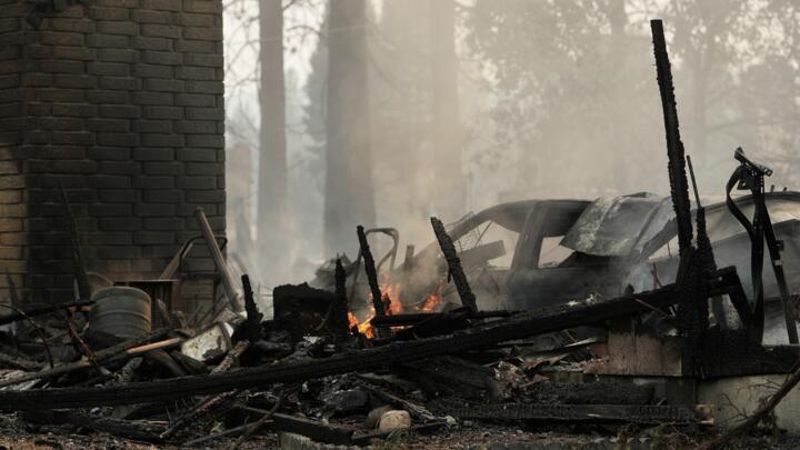 A house on N. Victor St. and W. Lyons Ave. burned by a wildfire smolders,  Aug. 2, 2026, in Spokane, Wash.