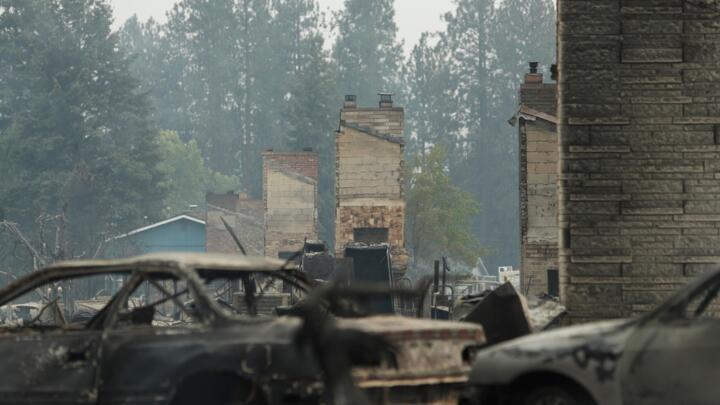 Debris is strewn around burned structures after a wildfire in Spokane, Washington, USA, on Sunday, August 2, 2026