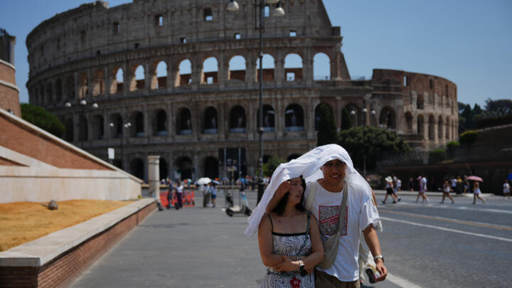 File photo of tourists trying to shelter from the sun near Rome's Colosseum taken August 1, 2026