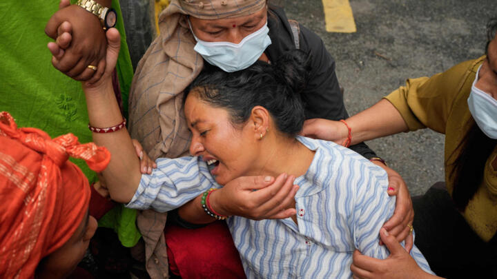 Relatives console Muna Khadka, who lost her son Aayush Khada, in flash floods, during mass burials in Chitwan, Nepal, Monday, Aug. 31, 2026.