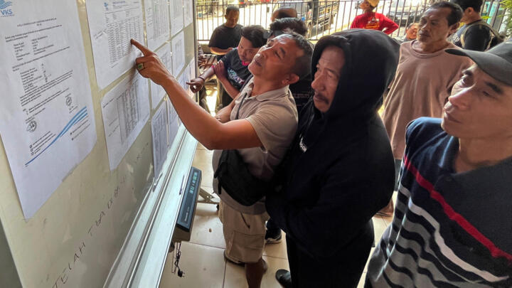 People check the passenger manifest of Virgo Transport 8 ferry at a rescue command center in Banjarmasin, Indonesia, September 14, 2026.