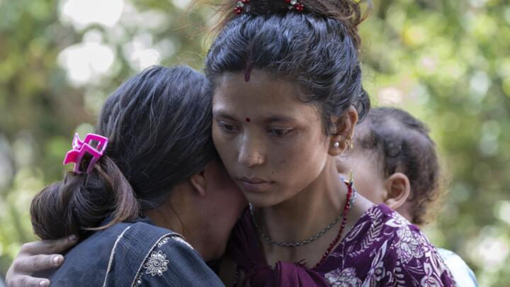 Familiares de las víctimas de las inundaciones permanecen fuera de la base militar donde los sobrevivientes son trasladados en helicóptero tras una crecida repentina en la aldea de Devighat, distrito de Nuwakot, Nepal, el 27 de agosto de 2026.