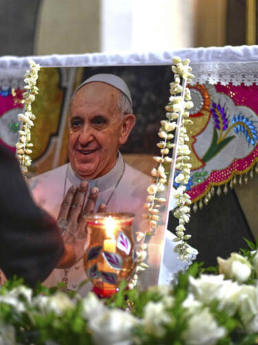 A Catholic nun touches a portrait of Pope Francis following the announcement of his death by the Vatican on April 21, 2025.