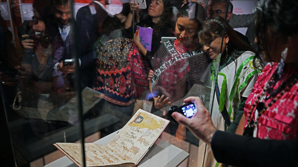 Attendees look at the Azcatitlan Codex, an ancient Aztec pictorial manuscript on loan from France, at the National Museum of Anthropology in Mexico City.