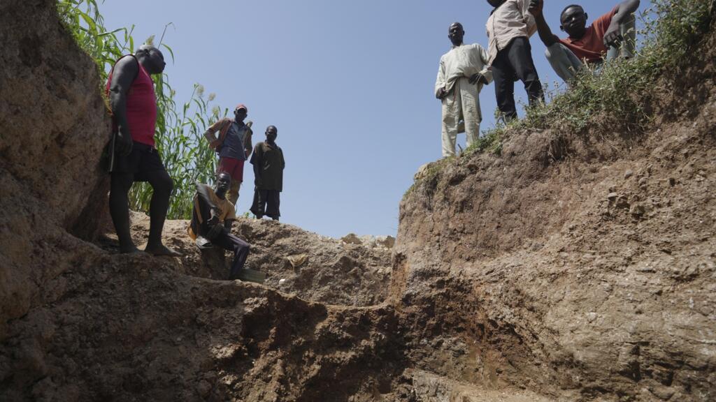 Workers stand at an illegal lithium mine in Paseli, Nigeria, 5 November 2024