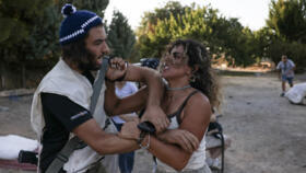 Alice Kisiya (R), whose family land was taken over by armed Israeli settlers, confronts a settler in the Makhrour area near Beit Jala in the occupied West Bank on August 22, 2024.
