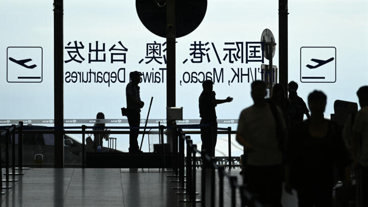 File photo: A security guard guides passengers at Beijing International airport on July 6, 2025.