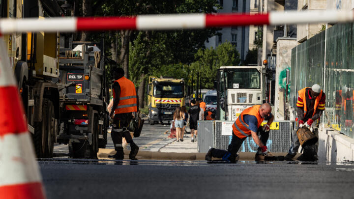 Workers spread asphalt on a street in Paris on June 22. 
