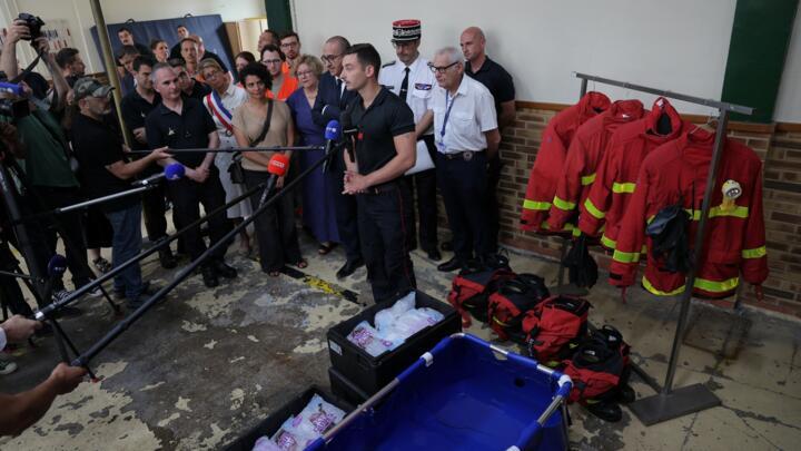 A firefighter speaks to the press while demonstrating an emergency cooling bath in Paris.