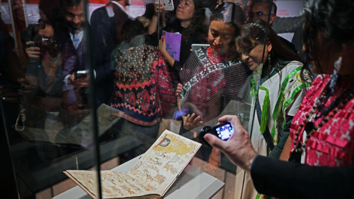 Attendees look at the Azcatitlan Codex, an ancient Aztec pictorial manuscript on loan from France, at the National Museum of Anthropology in Mexico City.