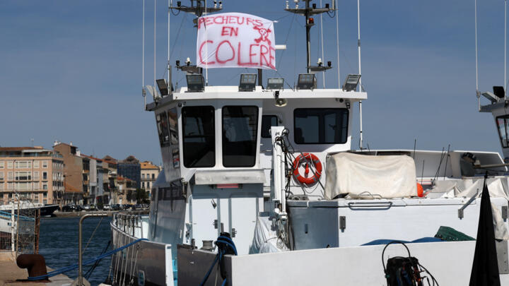 A banner reading "angry fishermen" on a fishing boat in the port of Sète, in southern France.