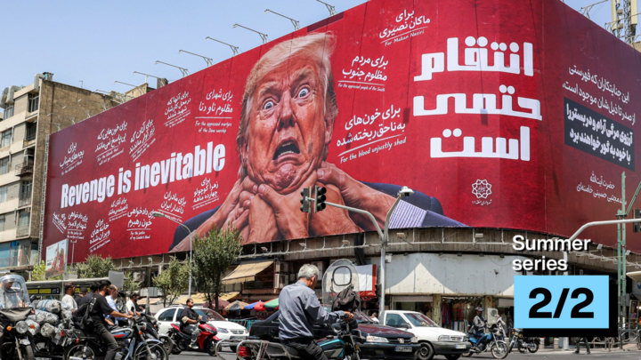 A woman walks past a large billboard pledging revenge against US President Donald Trump along Jomhouri Street in central Tehran on July 27, 2026.